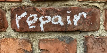 Word "repair" written with chalk on a wall.